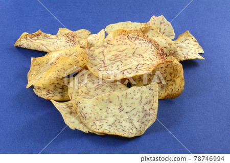 Pile of crunchy taro vegetable chips with sea salt on blue background Pile of crunchy taro vegetable chips with sea salt on blue background 78746994