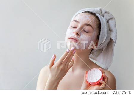 Beauty portrait of woman in towel on head with white nourishing mask or creme on face, white background isolated. Skincare cleansing eco organic cosmetic spa relax concept. Beauty portrait of woman in towel on head with white nourishing mask or creme on face, white background isolated. Skincare cleansing eco organic cosmetic spa relax concept. 78747568