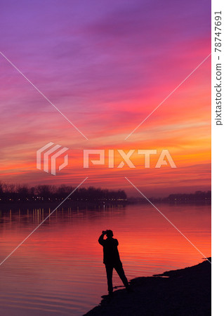Silhouette of a man taking a photo of a beautiful sunset sky; With copy space Silhouette of a man taking a photo of a beautiful sunset sky; With copy space 78747691