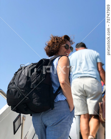 Woman tourist passanger boarding a plane at airport.Summer holidays. Woman tourist passanger boarding a plane at airport.Summer holidays. 78747909