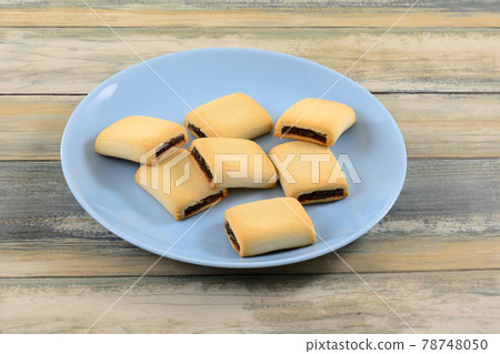 Date filled maamoul cookies on blue snack plate on table 78748050