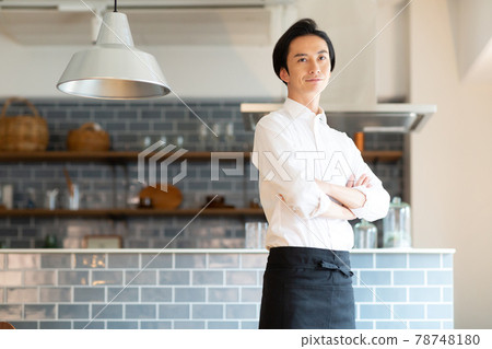 一個穿著圍裙站在廚房裡的男人 一個穿著圍裙站在廚房裡的男人 78748180