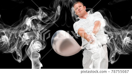 Caucasian male golf player swinging golf club against smoke effect on black background 78755087