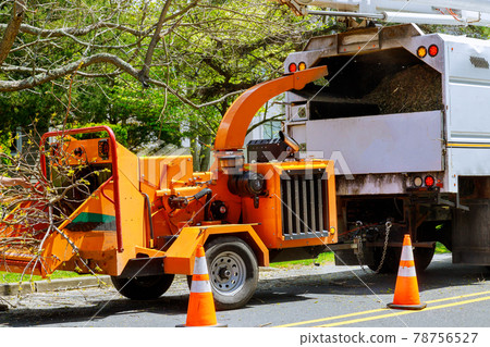Wood chipper loaded cut green tree branches in urban neighborhood. Wood chipper loaded cut green tree branches in urban neighborhood. 78756527