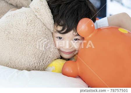 boy playing with a stuffed animal boy playing with a stuffed animal 78757501