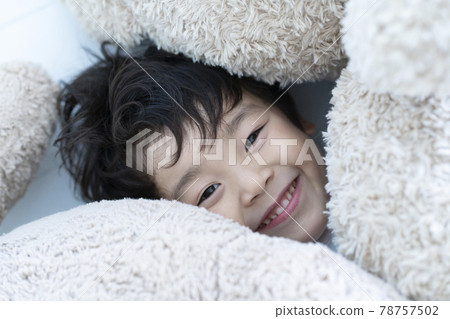 boy playing with a stuffed animal boy playing with a stuffed animal 78757502