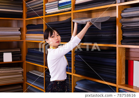 Modern Chinese salesgirl working in fabric store Modern Chinese salesgirl working in fabric store 78758616