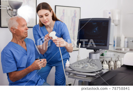 Portrait of young technician showing new ultrasound scan to doctor in clinic Portrait of young technician showing new ultrasound scan to doctor in clinic 78758841