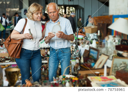 Elderly couple in flea market chooses antique items Elderly couple in flea market chooses antique items 78758961