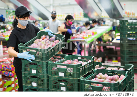 Woman in mask during packaging mango Woman in mask during packaging mango 78758978