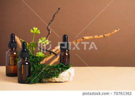 Set of bottles with serum or oil with natural materials on brown and beige background Set of bottles with serum or oil with natural materials on brown and beige background 78761362