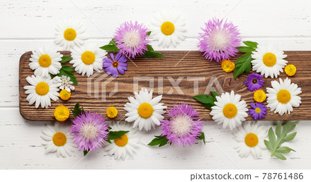 Various garden flowers over wooden background 78761486
