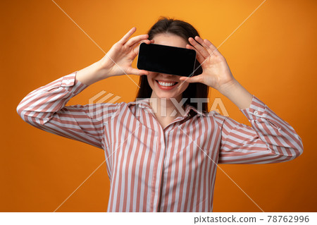 Happy smiling young woman showing you black smartphone screen with copy space Happy smiling young woman showing you black smartphone screen with copy space 78762996