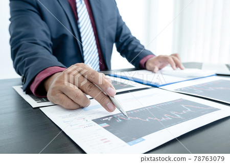Hand of businessmen are planning business investments related to shares By analyzing and calculating the stock market for marketing profits Hand of businessmen are planning business investments related to shares By analyzing and calculating the stock market for marketing profits 78763079
