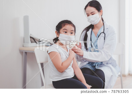 Asian child wearing face mask getting vaccinated during coronavirus or covid-19 pandemic at hospital,Vaccination concept Asian child wearing face mask getting vaccinated during coronavirus or covid-19 pandemic at hospital,Vaccination concept 78763305