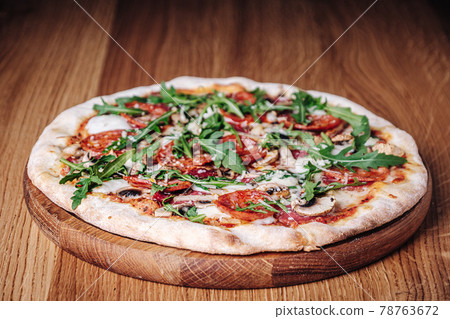 Appetizing Pizza on a Wooden Board in a Restaurant 78763672