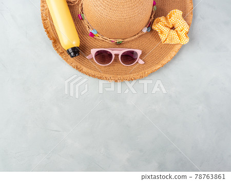 Summer lady straw hat, yellow sun protection spray and sunglasses on turquoise stone background. 78763861