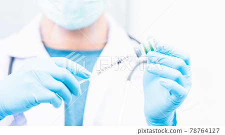 Doctor man pull syringe on liquid bottle COVID-19 (coronavirus) vaccine for injection at hospital 78764127