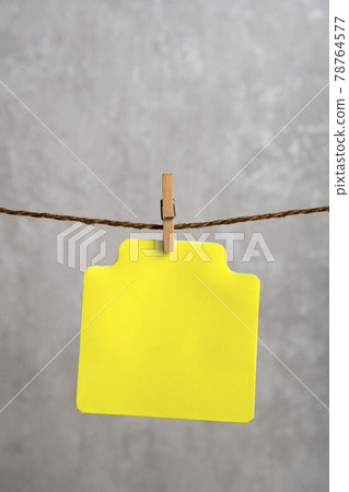 Blank yellow paper card hang with clothespin on rope. Copy space. Place for your text. Blank yellow paper card hang with clothespin on rope. Copy space. Place for your text. 78764577