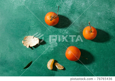 still life with mandarins on green background 78765436