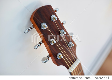 close up of acoustic guitar head with pegs 78765441