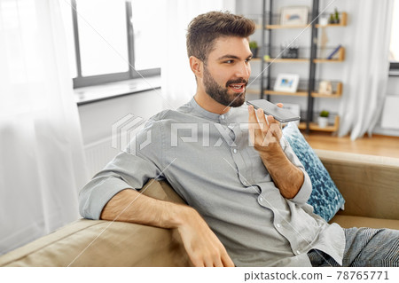 happy man with smartphone recording voice at home happy man with smartphone recording voice at home 78765771