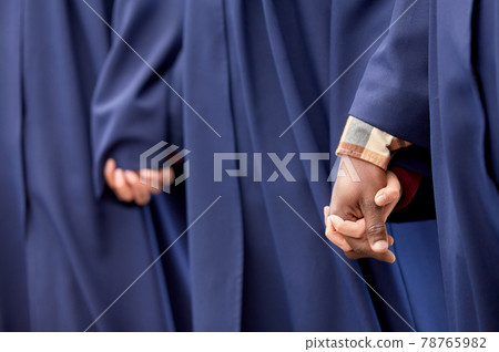 close up of graduate students holding hands close up of graduate students holding hands 78765982