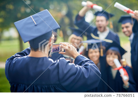 graduate students taking photo with smartphone graduate students taking photo with smartphone 78766051