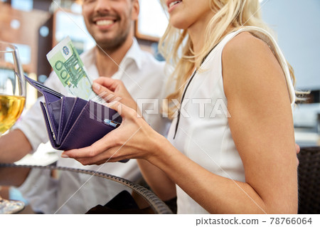 close up of couple with money paying at restaurant 78766064