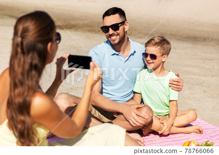 family with smartphone photographing on beach family with smartphone photographing on beach 78766066