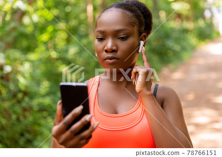african american woman with earphones and phone african american woman with earphones and phone 78766151