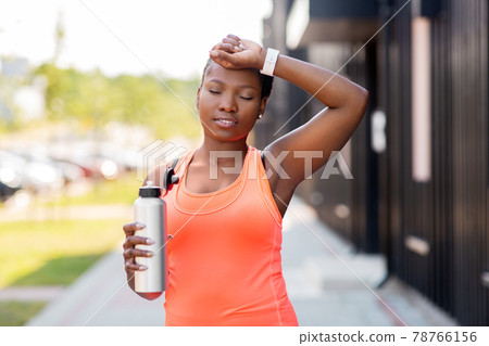 tired african american woman with bottle of water tired african american woman with bottle of water 78766156