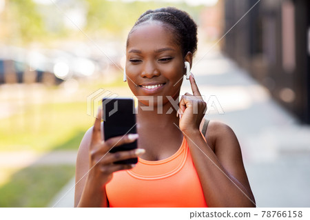 african american woman with earphones and phone african american woman with earphones and phone 78766158