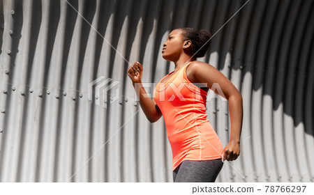young african american woman running in tunnel 78766297