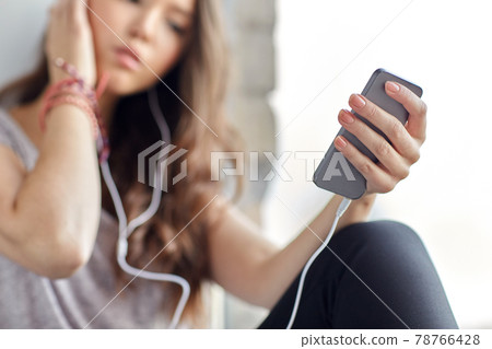 teenage girl with smartphone and earphones teenage girl with smartphone and earphones 78766428