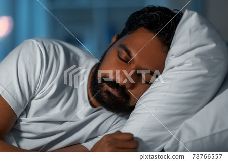 indian man sleeping in bed at home at night indian man sleeping in bed at home at night 78766557