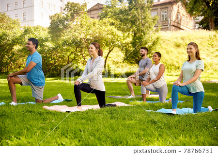 group of people doing yoga at summer park 78766731
