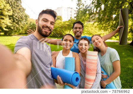 people with yoga mats taking selfie at park people with yoga mats taking selfie at park 78766962