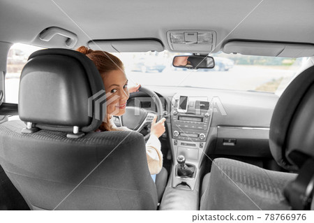 smiling woman or female driver driving car in city smiling woman or female driver driving car in city 78766976