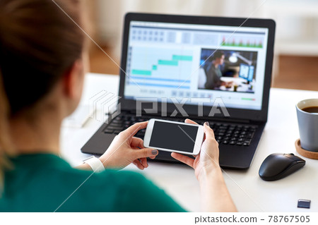 woman smartphone and laptop working at home woman smartphone and laptop working at home 78767505