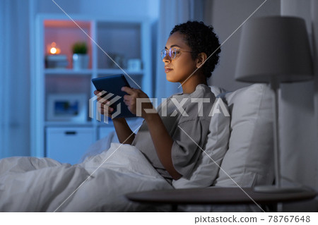 woman with tablet pc in bed at home at night 78767648