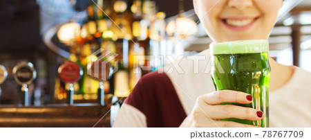 close up of woman with green beer in glass close up of woman with green beer in glass 78767709