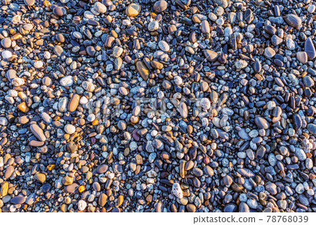 Small stones on the beach at sunset time. Small stones on the beach at sunset time. 78768039