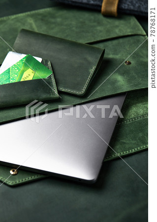 Fashion, handmade leather goods on a wooden table matched to the color of the skin. Cases for credit cards, laptop, money top view, close-up. 78768171