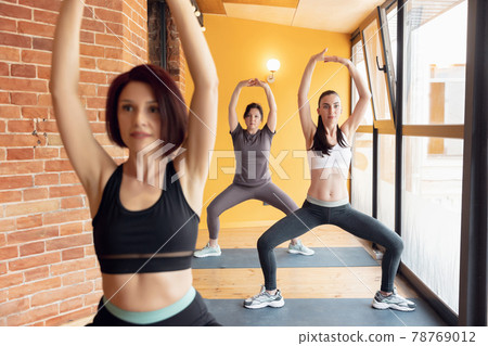 Group of young women in the gym centre. Yoga. Group of young women in the gym centre. Yoga. 78769012