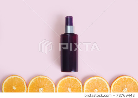Unbranded dark brown spray bottle and line of orange slice circles on pink background. Cosmetic packaging mockup. Template, front view. Natural organic spa Body mist. Cream bottle with vitamin c. Unbranded dark brown spray bottle and line of orange slice circles on pink background. Cosmetic packaging mockup. Template, front view. Natural organic spa Body mist. Cream bottle with vitamin c. 78769448