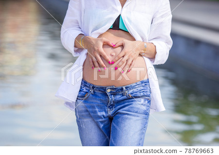Pregnant woman in outdoor park, warm weather 78769663