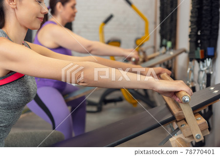 Athletic multinational people doing exercise with elastic rope in gym 78770401