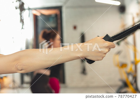 Athletic multinational people doing exercise with elastic rope in gym Athletic multinational people doing exercise with elastic rope in gym 78770427
