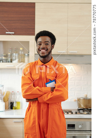 Cheerful Afro American plumber at kitchen Cheerful Afro American plumber at kitchen 78770775